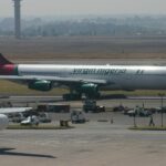 Virgin Nigeria Airbus A340 parked at Johannesburg O.R. Tambo International Airport terminal